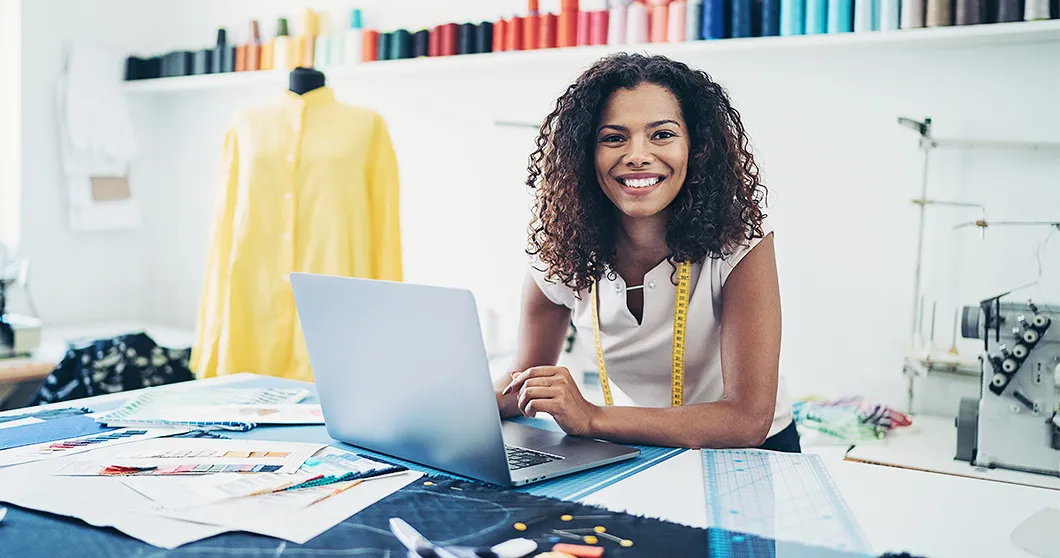 Modedesignerin im Studio mit Laptop